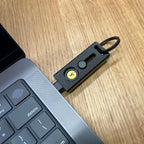 Wysuwane czarne etui do klucza Yubikey  5 wpięte do komputera macbook.