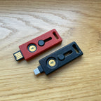 Lock Nest Slide Duo Primary Backup zestaw dwóch etui w kolorze czarnym primary i czerwonym backup. Pełna ochrona dla Twoich kluczy sprzętowych YubiKey Oba klucze leżą na biurku USB A i USB C
