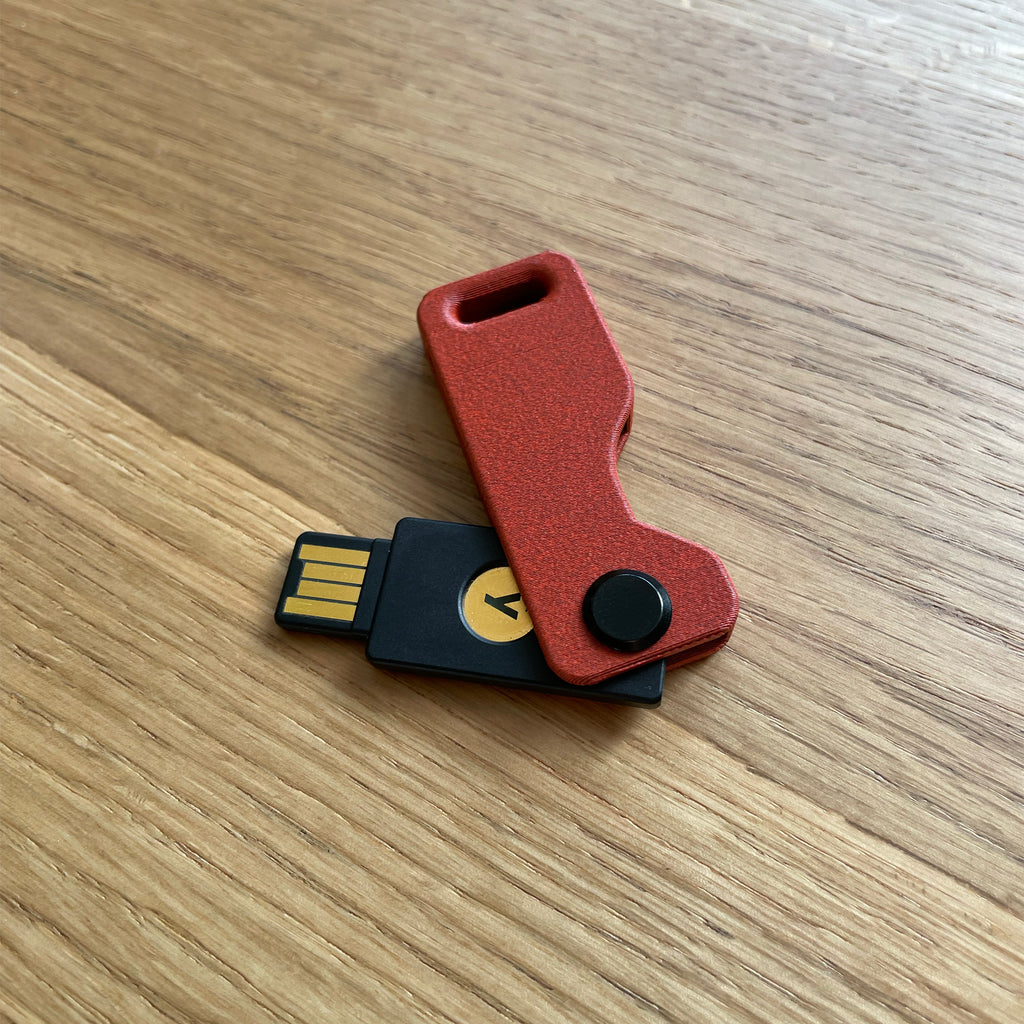 Czerwone etui Lock Nest Orbit red brick leży na dębowym biurku USB A