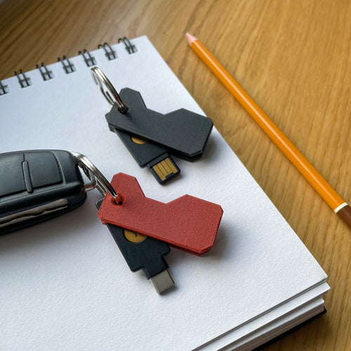 Etui Lock Nest Pivot na notesie obok klucza YubiKey